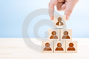 Management hierarchy pyramid with wooden cubes. Human resources, corporate hierarchy concept and multilevel marketing - recruiter