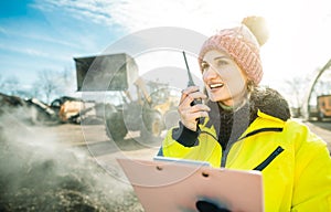 Manager in biomass and landfill operation using her radio in front of machines