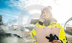 Manager in biomass and landfill operation using her radio in front of machines