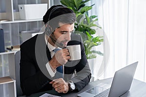 Manager of call center operator office sitting on his desk with coffee. fervent