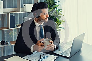 Manager of call center operator office sitting on his desk with coffee. fervent