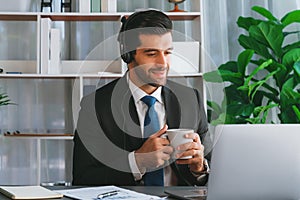 Manager of call center operator office sitting on his desk with coffee. fervent