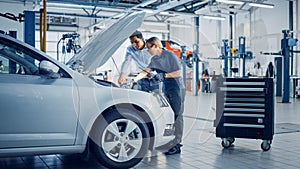 Manager Checks Data on a Tablet and Explains an Engine Breakdown to an Empowering Female Mechanic.