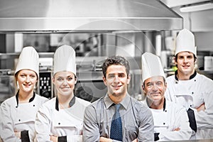 Manager with chefs portrait in professional kitchen photo