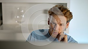 Manager contemplating analyzing data on computer screen at remote office closeup