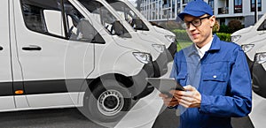 Manager with a digital tablet on the background of delivery van. Fleet management.