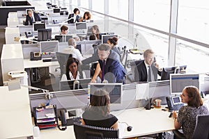 Manager in discussion with coworker in an open plan office photo