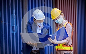 Manager and dock worker under discussion about dock container shipping warehouse document, they wearing safety uniform hard hat ,f