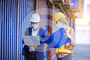 Manager and dock worker under discussion about dock container shipping warehouse document, they wearing safety uniform hard hat ,f