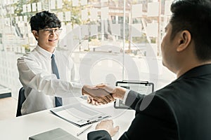 Manager and employee interview concept with handshake after talking about contract signing
