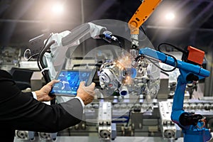 Manager engineer touch screen control automation robot arms the production of factory parts engine manufacturing industry robots a