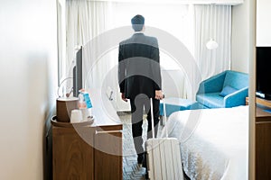 Manager Entering Hotel Room With Luggage
