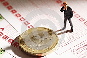 Manager figurine standing on betting slip with euro coin, close up