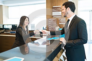 Manager Finalizing Reservation While Paying At Lobby