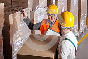 Manager giving worker instruction in warehouse photo