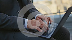 Manager hands typing keyboard closeup. Urban businessman in suit work laptop