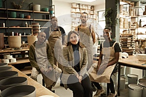 Manager and her diverse team smiling in a ceramics studio