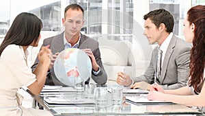 Manager holding a terrestrial globe in a meeting