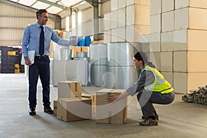 Manager instructing female worker while working