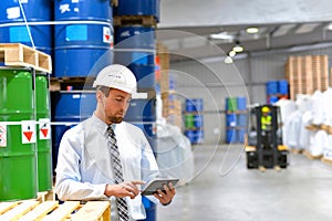 Manager in a logistic company work in a warehouse with chemicals