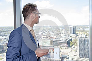 The manager in the office on the top floor stand front of the window