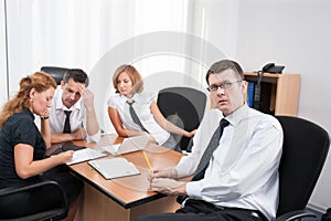 Manager with office workers in board room