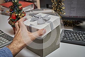 Manager opening a gift box on working place