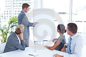 Manager presenting whiteboard to his colleagues