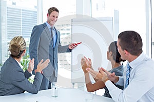 Manager presenting whiteboard to his colleagues