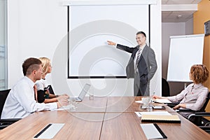 Manager presenting whiteboard to his colleagues