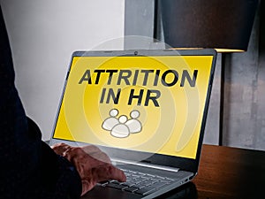 Manager reads about attrition in hr on the screen.