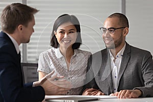 Manager realtor banker consulting happy diverse young couple at meeting