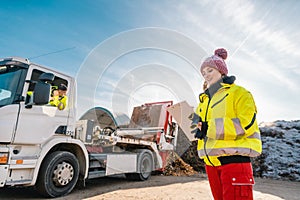 Manager registering truck unloading biomass in compost works