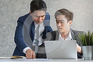 Manager reviewing work of intern worker