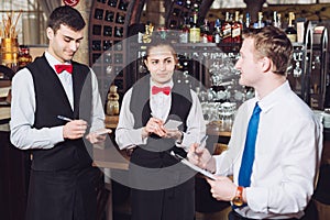 Manager`s briefing with the waiters. Restaurant manager and his staff photo