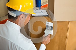 Manager Scanning Cardboard Box With Barcode Scanner