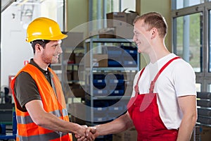 Manager shaking hands with factory worker