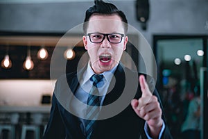 Manager shouting and pointing finger at employee because he is very angry from Sales reports and financial reports decreased.