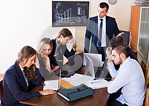 Manager shouting to employees at group meeting