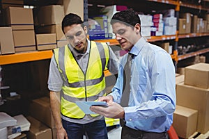 Manager showing tablet to worker