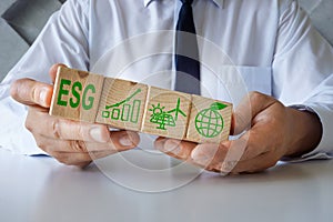 Manager shows cubes with ESG Environmental, Social and Corporate Governance symbols. photo