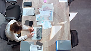 Manager sits at workplace with different documents