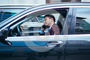 A manager sitting in his limo and discussing and planning his business movies, while applying a lot of body language in his