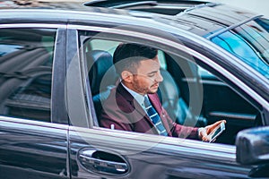 A manager sitting in his limo and discussing and planning his business movies, while applying a lot of body language in his