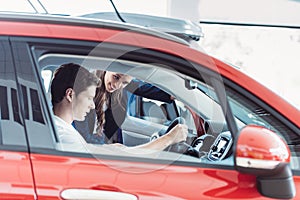 Manager speaking to customer sitting in a car