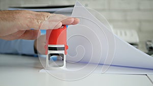 Manager Stamping Some Papers and Documents Using a Rubber Stamp in Slow Motion