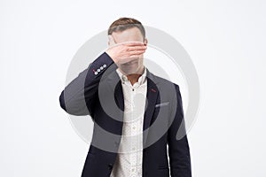Manager in suit covering his face with hand. Negative news at work.