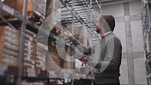 Manager With Tablet PC Checking Goods At Supermarket Warehouse. Modern Furniture Stock