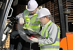 Manager talking with forklift operator