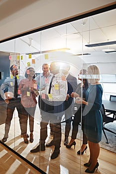 Manager using sticky notes during a team brainstorming session